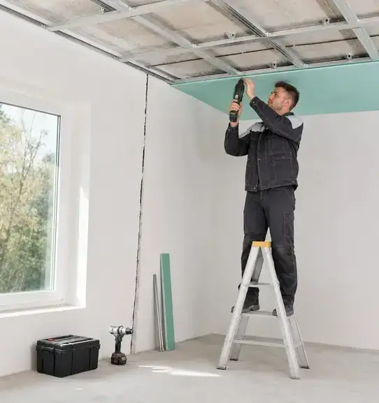 Worker installing a new drywall ceiling panel during ceiling water damage repair in Franklin, TN